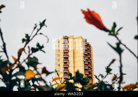 Moderno edificio di appartamenti si trova nei pressi di aiuola contro il cielo grigio sulla strada di Tenerife Foto Stock