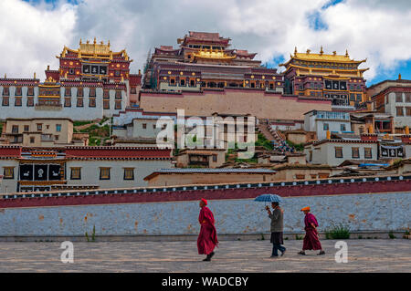 I monaci del Tibet a piedi nella parte anteriore del monastero Songzanlin, noto anche come Ganden Sumtseling Gompa in Zhongdian, Shangri La, nella provincia dello Yunnan in Cina. Foto Stock