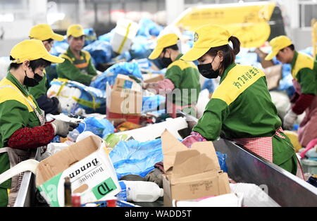 Lavoratori cinesi di riordinare gli elementi riciclabili presso il centro di distribuzione di un ambiente azienda in Hangzhou, est della Cina di provincia dello Zhejiang, 8 lug Foto Stock
