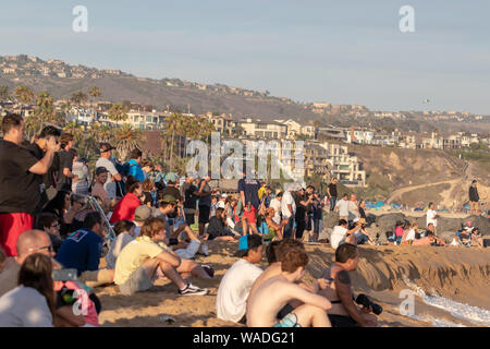 Gli spettatori presso il cuneo di Newport Beach in California a guardare la gente bodyboarding e surf Foto Stock