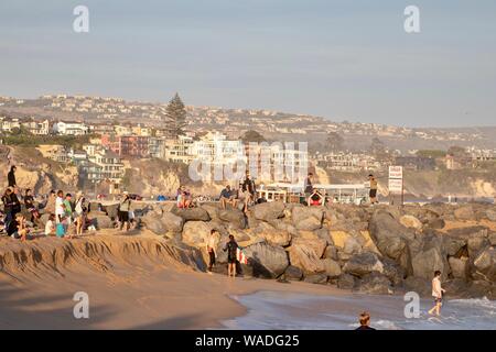 Gli spettatori presso il cuneo di Newport Beach in California a guardare la gente bodyboarding e surf Foto Stock