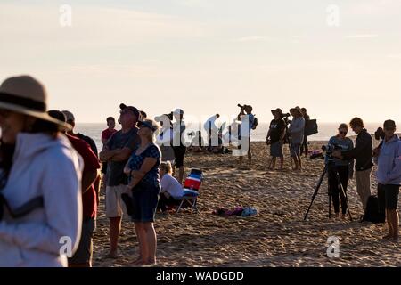 Gli spettatori presso il cuneo di Newport Beach in California a guardare la gente bodyboarding e surf Foto Stock