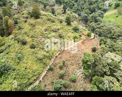 Country Road in montagna intorno a verdi colline antenna fuco view Foto Stock