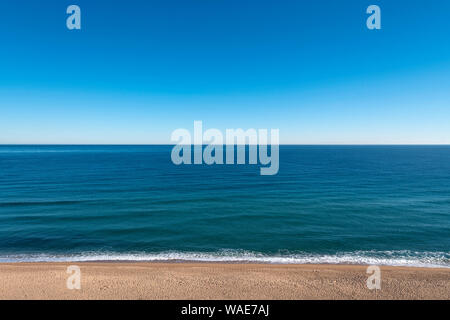 Al di sopra di vuoto spiaggia sabbiosa con ampia calma mare orizzonte Foto Stock