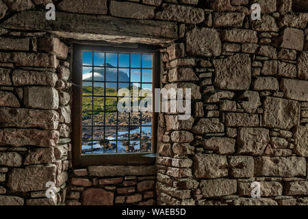 Guardando attraverso una finestra in un muro di pietra per l'Isola di Skye in Scozia Foto Stock