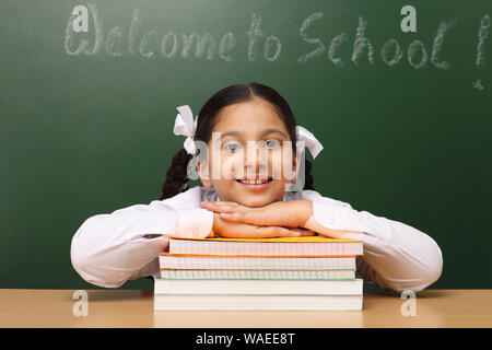 Ritratto di una scolaretta con libri in una classe Foto Stock