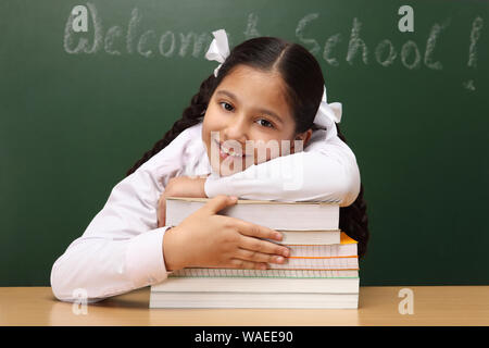 Ritratto di una scolaretta con libri in una classe Foto Stock