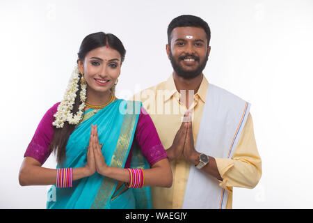 Sud indiane giovane saluto e sorridendo alla telecamera Foto Stock