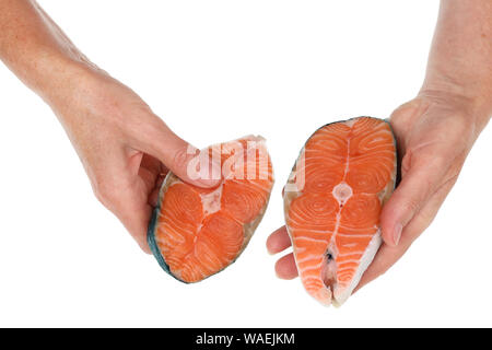 Una vecchia donna senior detiene un filetti di salmone le mani . Isolato su bianco studio concept Foto Stock