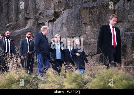 Thingvellir, Germania. 19 Ago, 2019. Il Cancelliere federale Angela Merkel (M) parla a Thingvellir Parco nazionale islandese con il Primo Ministro Katrín Jakobsdóttir (secondo da destra) e Direttore del Parco Einar Saemundsen (quinto da destra). Il cancelliere della visita in Islanda è stato richiesto dalla riunione annuale di Scandinavian capi di governo al quale era stata invitata. Credito: Steffen Trumpf/dpa/Alamy Live News Foto Stock