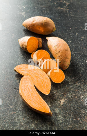 Le patate dolci sul vecchio tavolo da cucina. Foto Stock