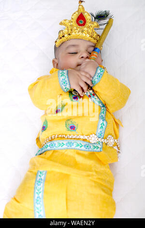 Foto di indiani bambina indossa Krishna costume e celebrando Janmashtami festival. Isolato sullo sfondo bianco. Foto Stock