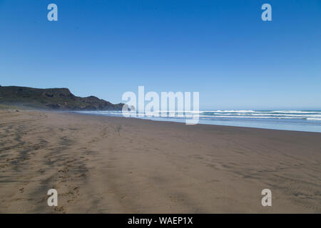 Torrida giornata calda a Bethells Beach, West Auckland. Sabbia nera diventa caldo. Splendide estati giorno a Te Henga con cielo blu e nuvole minima. Grotte del sud Foto Stock