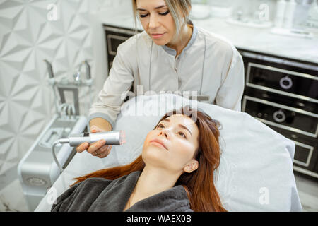 Cosmetologo femmina rendendo mesoterapia ossigeno ad una donna presso il lussuoso salone di bellezza. Concetto di un professionista del trattamento del viso Foto Stock