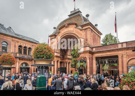 I visitatori a piedi attraverso il portale dei giardini di Tivoli a Copenhagen, in Danimarca, 16 agosto 2019 Foto Stock