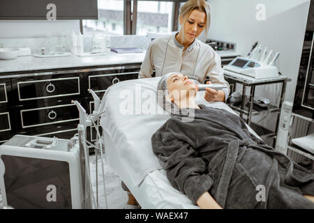 Cosmetologo femmina rendendo mesoterapia ossigeno ad una donna presso il lussuoso salone di bellezza. Concetto di un professionista del trattamento del viso Foto Stock