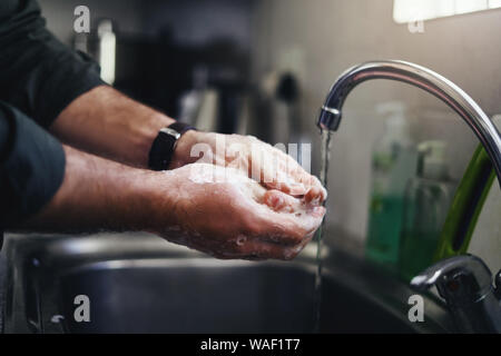 Man mano di lavaggio con lavello rubinetto Foto Stock