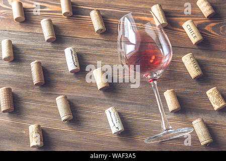 Bicchiere di vino rosso la posa su sfondo di legno Foto Stock