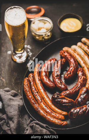 Cena bavarese con birra chiara, salsicce, la salsa in vasi Foto Stock