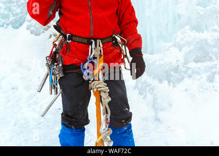 Arrampicata attrezzature mettere su un alpinista close up Foto Stock