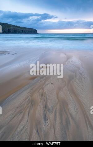 L'acqua fluisce attraverso la bizzarra strutture sulla spiaggia di sabbia nel mare, Dalmore Beach, isola di Lewis, Scozia Foto Stock