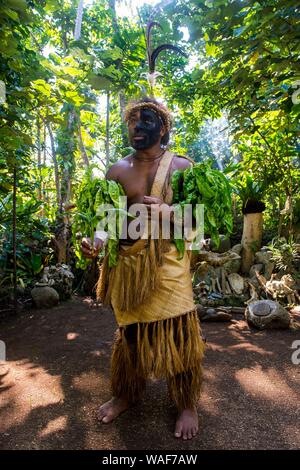 Vestito tradizionale uomo con faccia nera nella giungla, Ekasup villaggio culturale, Efate, Vanuatu Foto Stock