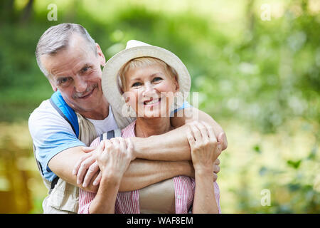 Ritratto di coppia felice coppia abbracciando e sorridente alla telecamera mentre spendere il loro tempo in natura Foto Stock