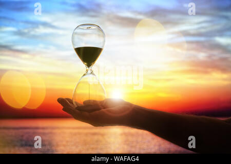 Tempo di clessidra al tramonto con uno sfondo con spazio di copia Foto Stock