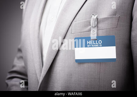 Imprenditore a una fiera o una conferenza che indossa un ciao il mio nome è identità di sicurezza scheda nome o tag Foto Stock