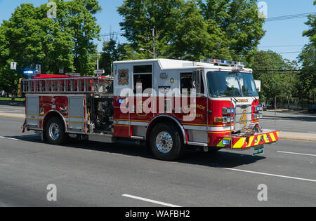 Long Island, NY - Circa 2019: Fire carrello aziona verso il basso street nel giorno memoriale della sfilata evento di celebrazione onore veterani militari e l'eroe locale. Emergency Foto Stock