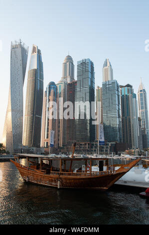 Un vecchio Dhow di legno ormeggiata in un ambiente moderno di Dubai Marina un affluente di quartiere residenziale a Dubai, Emirati Arabi Uniti. Foto Stock