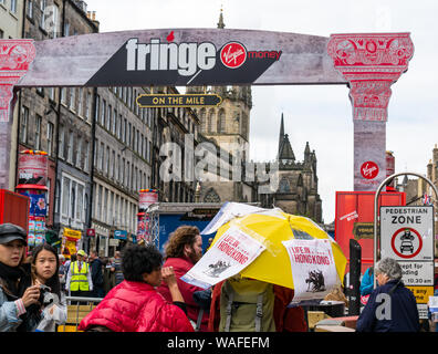 Edimburgo, Scozia, Regno Unito, 20 agosto 2019. Edinburgh Festival Fringe: esecutori sul Royal Mile tentare di attirare le persone per i loro spettacoli. Artisti provenienti da uno spettacolo chiamato Vita in Hong Kong, un mime sulla vita quotidiana e scene di Hong Kong Foto Stock