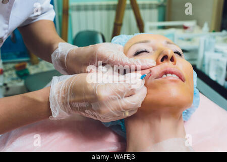 In prossimità di una filettatura mani belle womans labbro superiore Foto Stock