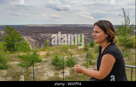 20 agosto 2019, Brandeburgo, Welzow: Annalena Baerbock, Presidente federale Bündnis 90/Die Grünen, sorge in un punto panoramico e guarda alla lignite Welzow-Süd miniera a cielo aperto di Lausitz Energie Bergbau AG (LEAG). Lo stesso giorno il candidato ha informato se stessa circa la fossa aperta miniera di lignite e circa il piano di istituire uno spazio europeo di lotta antincendio squadrone per l'Europa del nord all'aviosuperficie Welzow. Su 01.09.2019 è in stato di Brandeburgo elezione. Foto: Patrick Pleul/dpa-Zentralbild/ZB Foto Stock