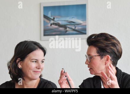 20 agosto 2019, Brandeburgo, Welzow: Annalena Baerbock (l), Presidente federale Bündnis 90/Die Grünen, parla di Birgit Zuchold (SPD), Sindaco di Welzow, durante una visita informativa sull' idea di un' Unione velivoli antincendio squadron' all'aeroporto di Welzow. Il candidato ha informato se stessa circa il progetto relativo alla creazione di uno spazio europeo di lotta antincendio squadrone per il Nord Europa. Su 01.09.2019 è in stato di Brandeburgo elezione. Foto: Patrick Pleul/dpa-Zentralbild/ZB Foto Stock