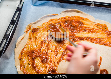 Freschi e originali Italian Pizza cruda preparazione di pasta con salsa di pomodoro in stile tradizionale. Foto Stock