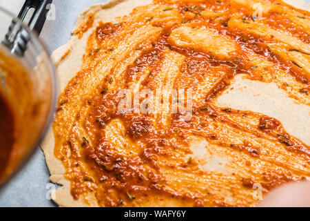 Freschi e originali Italian Pizza cruda preparazione di pasta con salsa di pomodoro in stile tradizionale. Foto Stock