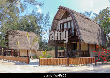 Indonesiani tradizionali bungalow sulla spiaggia di sabbia bianca in un paradiso tropicale. Yoglo in legno con tetto a lamelle su Gili Meno isola in Indonesia. Semplice bambù. Foto Stock