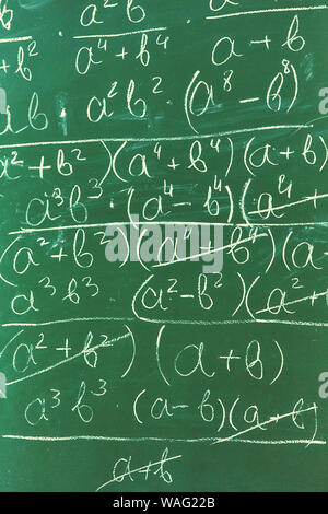 Le formule matematiche scritto da gesso bianco sullo sfondo della lavagna Foto Stock