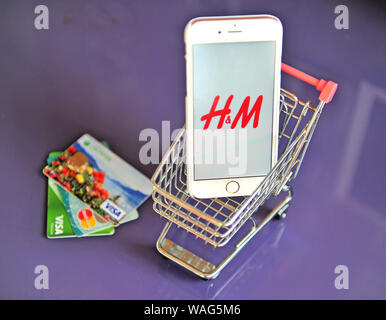 Yaroslavl, Russia - Agosto 20, 2019: Smartphone con H&M logo nel carrello della spesa e le carte di credito sul tavolo. Foto Stock