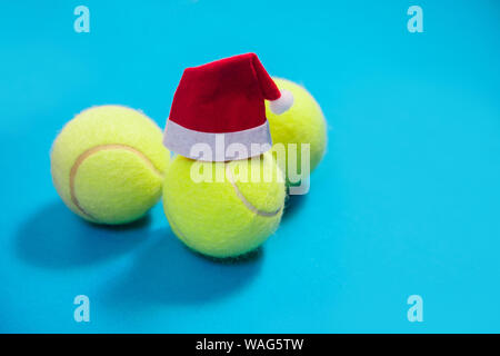 Santa hat sulla palla da tennis su sfondo blu Foto Stock