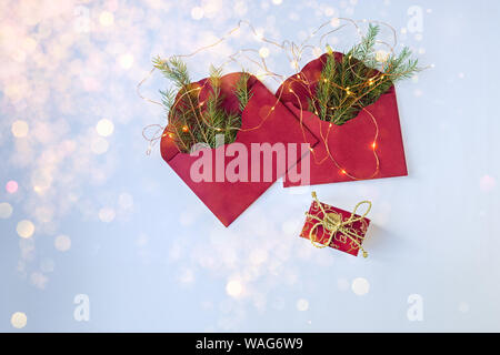 Due buste rosse con rami di abete. vista dall'alto. Regalo per l'anno nuovo. Foto Stock