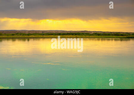 La fauna selvatica lontano dalla civiltà. Fiume con al tramonto. In contrasto cielo sopra il fiume. Golden raggi del sole al tramonto. Blu puro fiume Fiume. Estate Foto Stock