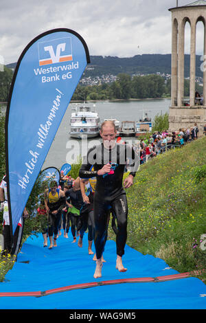 Neuwied, Renania Palatinato, Germania - 18 agosto 2019: i concorrenti della società Raiffeisen triathlon dopo una nuotata in esecuzione per la loro corsa biciclette Foto Stock