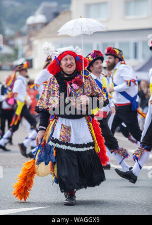 Un pazzo con morris ballerini folk a Sidmouth Folk Week Festival 2019 Foto Stock