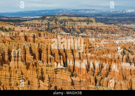 Parte centrale del Bryce Canyon (Bryce anfiteatro) in primavera. Alcuni resti di neve sulle cime di scogli colorati e pinnacoli. Le montagne in distanza Foto Stock