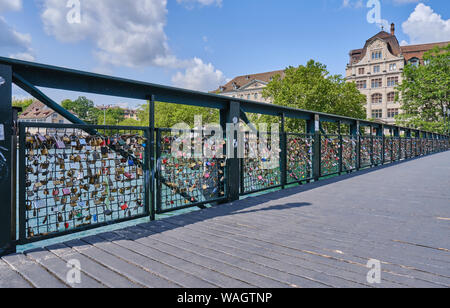 Amore si blocca sulla ringhiera a ponte sul fiume in città contro Sky Foto Stock