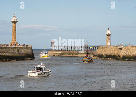 Imbarcazioni da diporto e di una barca da pesca all'ingresso al porto di Whitby, North Yorkshire, Inghilterra, Regno Unito Foto Stock