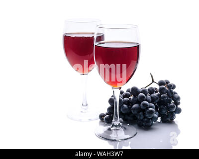 Vino rosso in bicchieri e un grappolo di uva nera su sfondo bianco. Composizione isolata Foto Stock