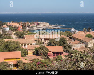 Gorea, Senegal - Febbraio 2, 2019: Vista di case con il tetto rosso sull'isola di Goree con Dakar in background. Gorée. Dakar, Senegal. L'Africa. Foto Stock